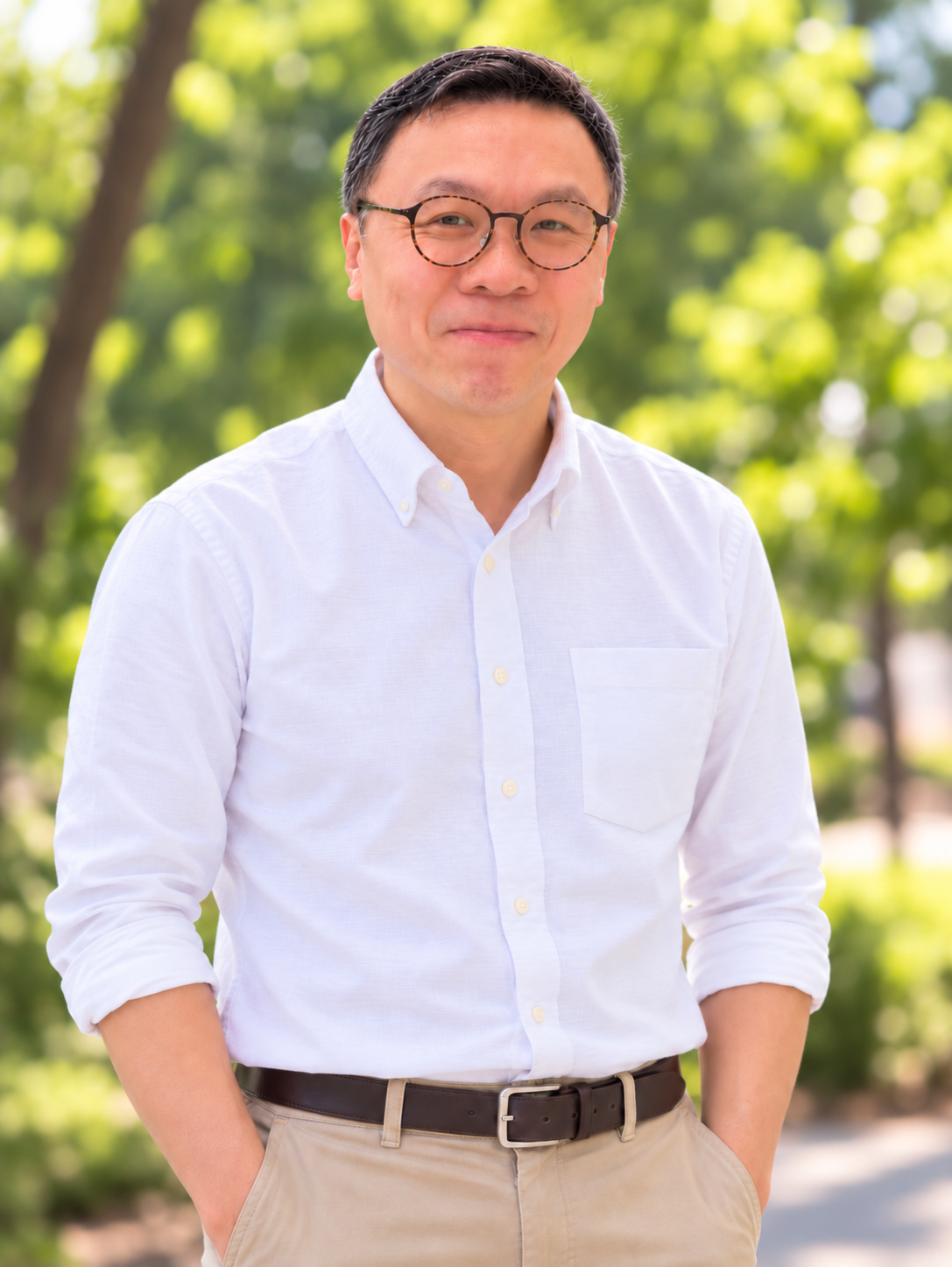Harry Chiang 的本人照片,穿著白色襯衫,背景為綠樹